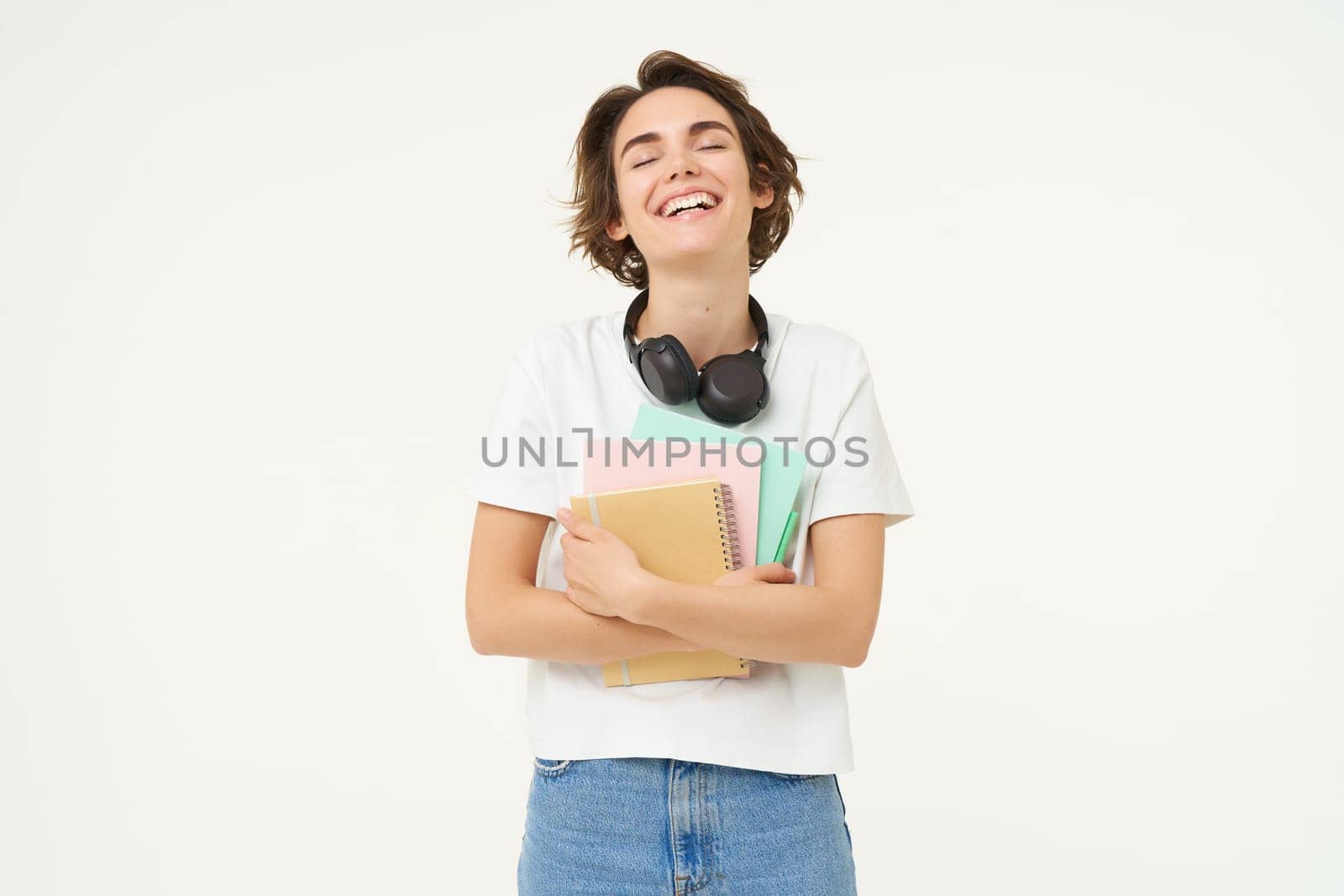 Image of stylish, modern girl student, holding workbook, documents. Woman teacher with papers standing over white background.