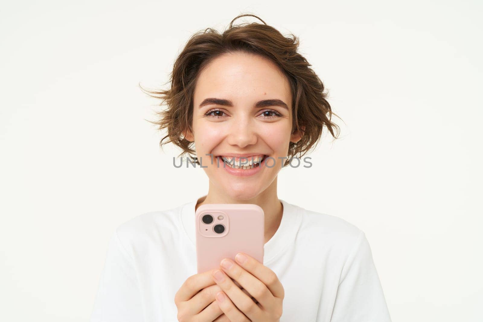 Close up of laughing smiling woman, holding smartphone, using mobile app, online shopping in application, scrolling social media, standing over white background.