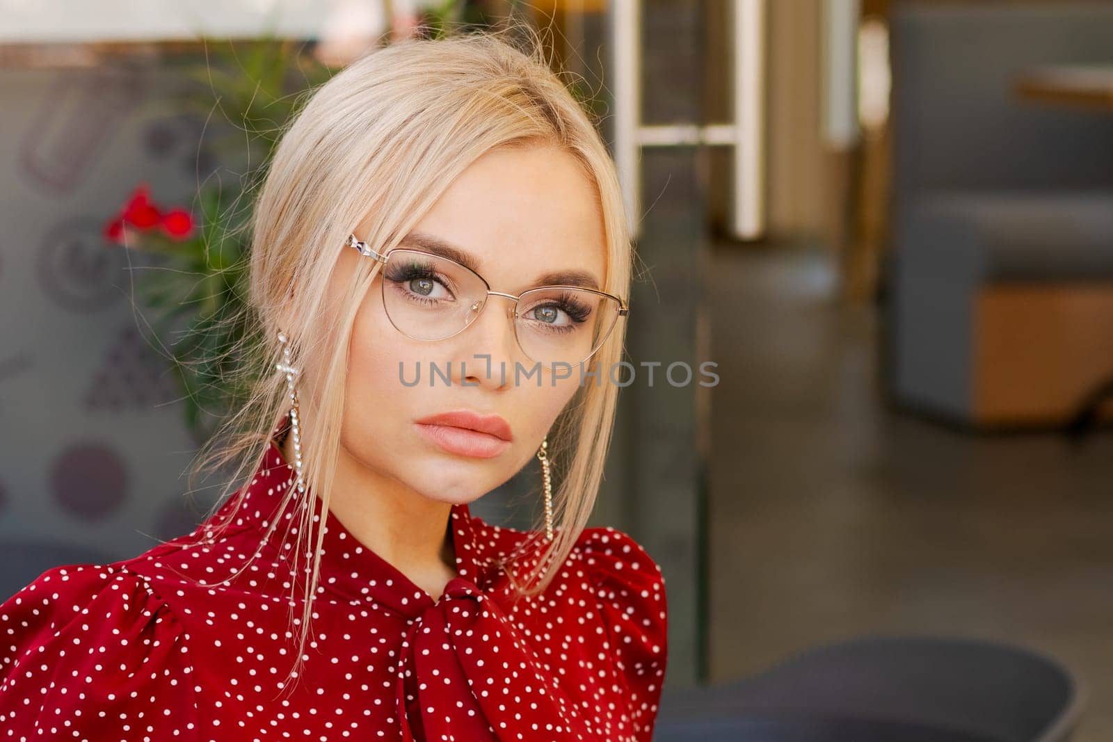 portrait of a beautiful blonde woman in glasses and a red dress