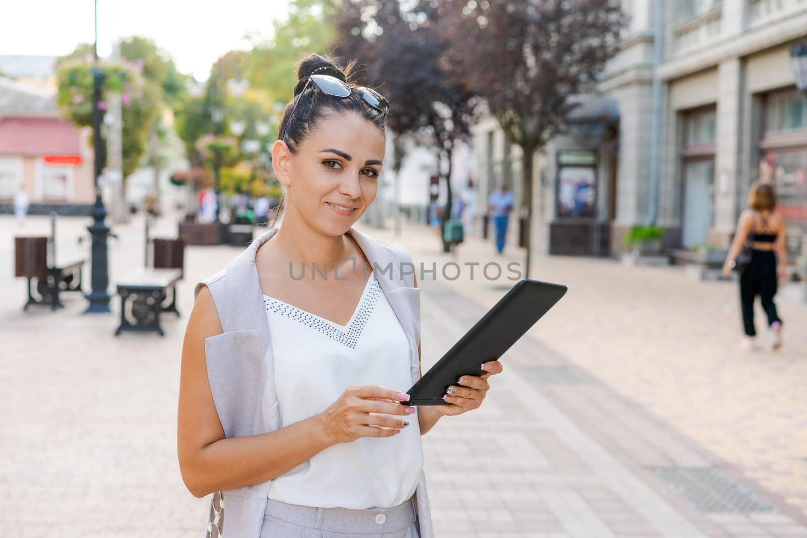 Successful businessman or entrepreneur smiling holding notepad while walking outdoor. City business woman working.