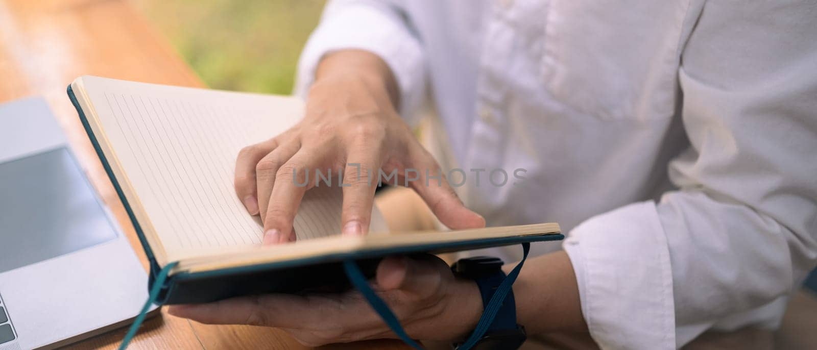 Cropped shot of businessman checking working schedule plan or important things on notebook by prathanchorruangsak