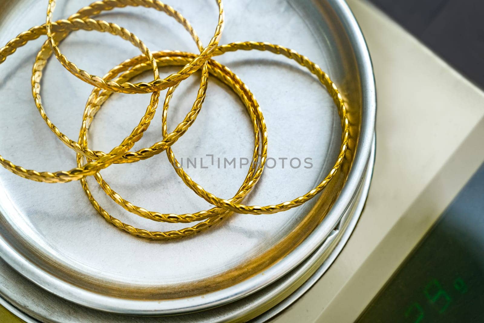 Stack of  24k (24 carat) Turkish gold twist bracelet on precision jeweler's scale by Sonat