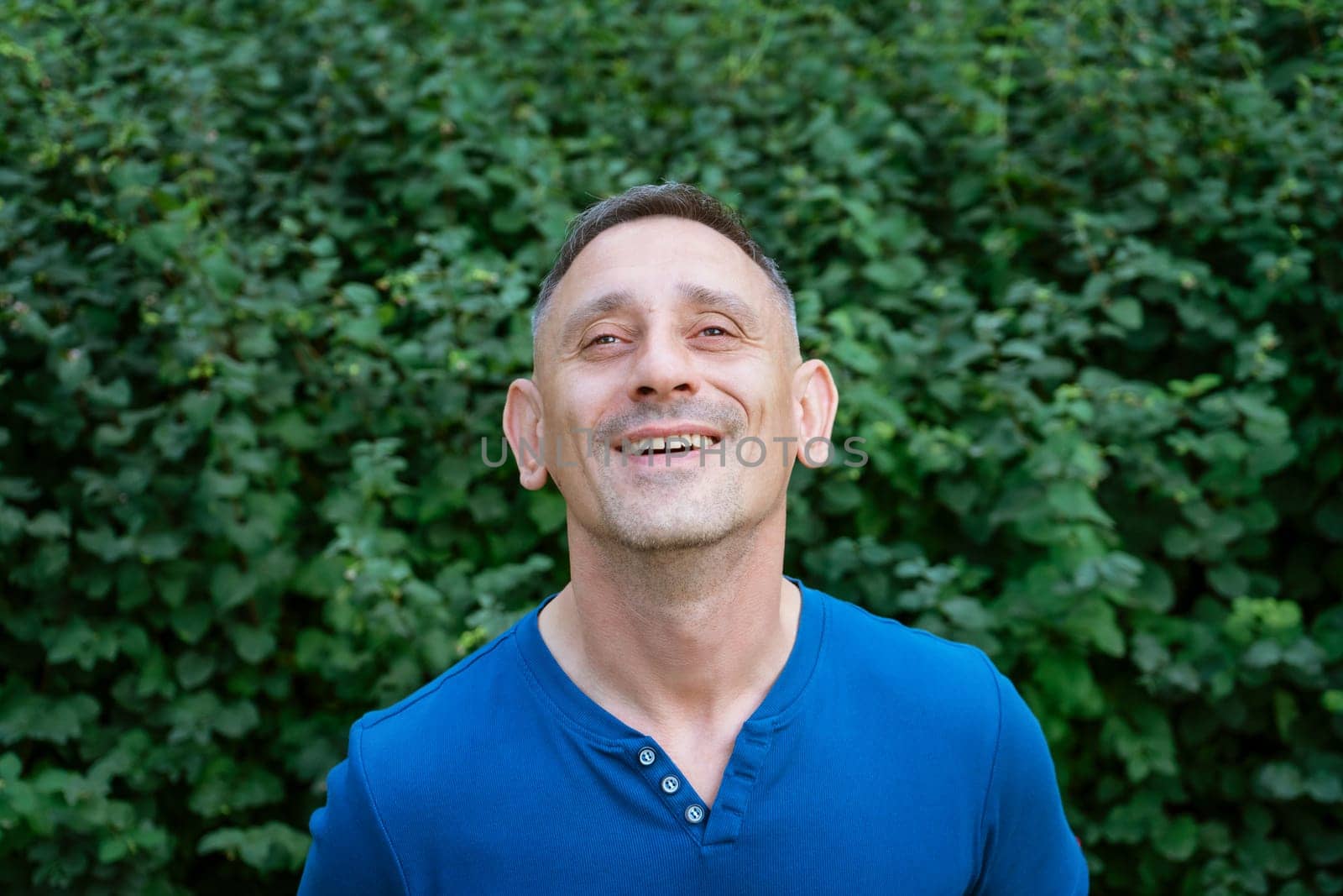 handsome portrait of a man in a blue T-shirt on a park by EkaterinaPereslavtseva