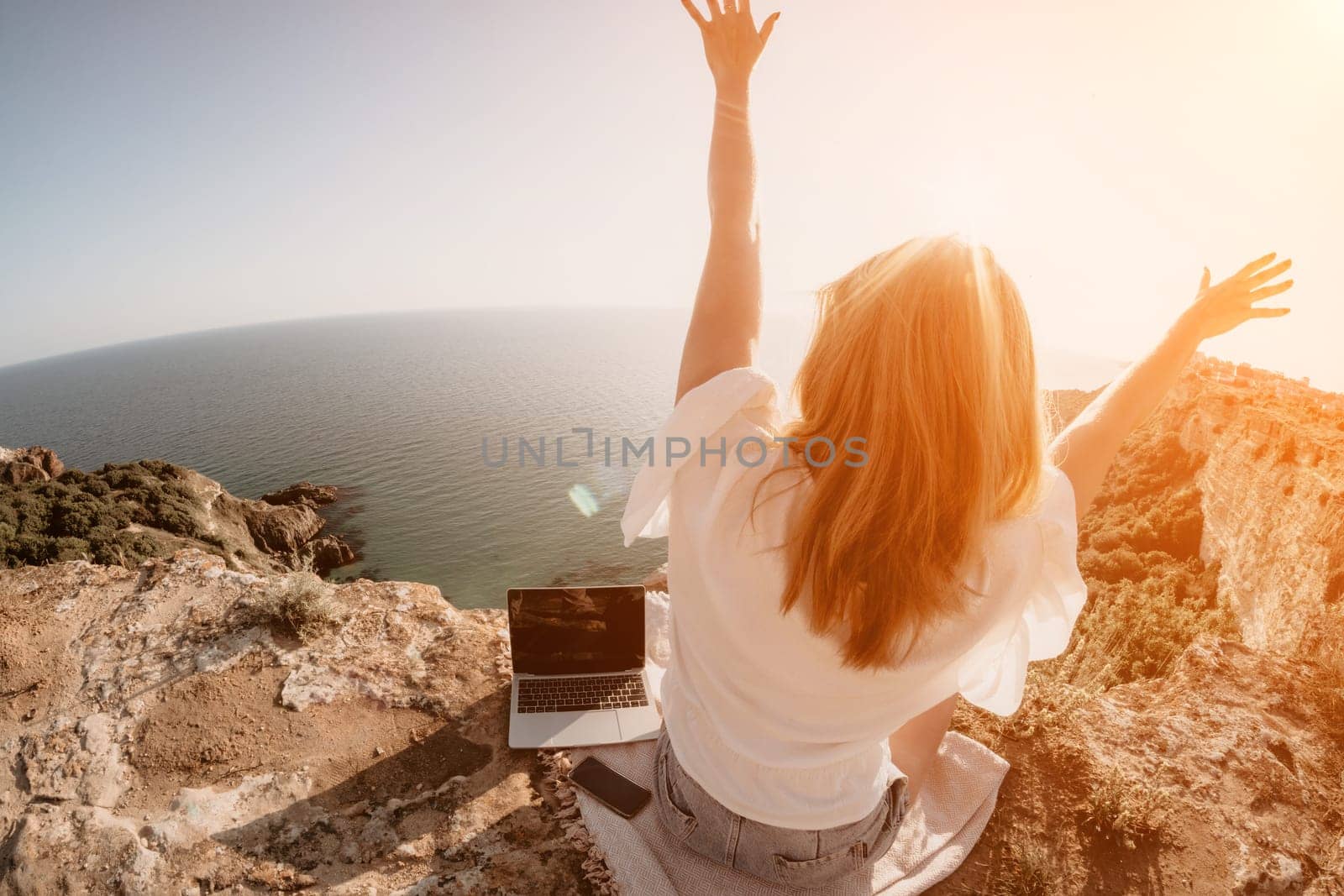 Woman sea laptop. Business woman in yellow hat working on laptop by sea. Close up on hands of pretty lady typing on computer outdoors summer day. Freelance, digital nomad, travel and holidays concept.