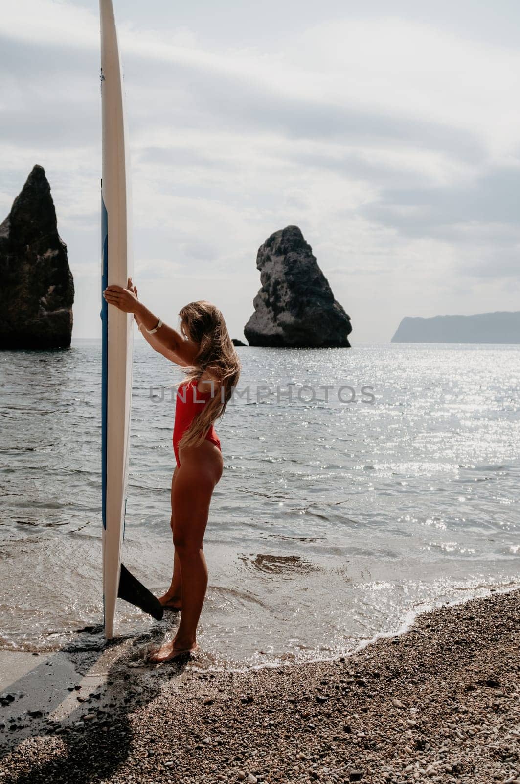 Woman sea sup. Close up portrait of happy young caucasian woman with long hair looking at camera and smiling. Cute woman portrait in bikini posing on sup board in the sea by panophotograph