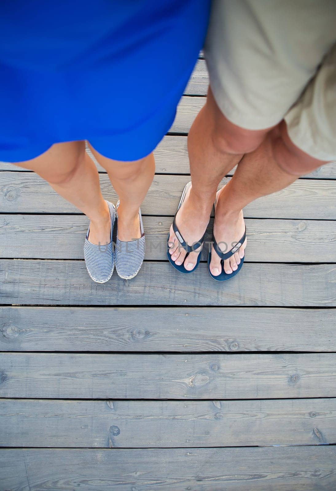 tanned guy and girl are standing on a wooden bridge by sfinks