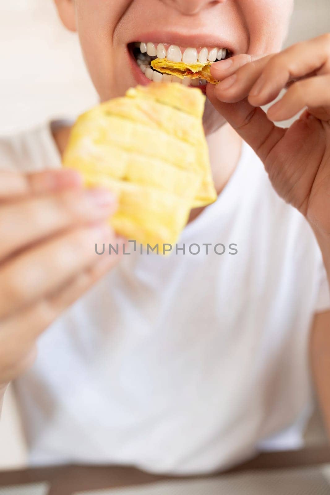 young woman taking a bite of homemade fast food.