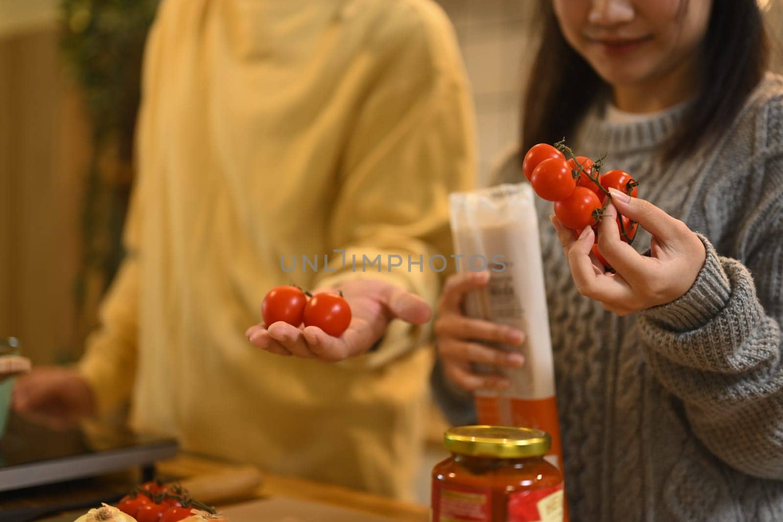 Young couple selecting fresh tomatoes for a delicious meal.