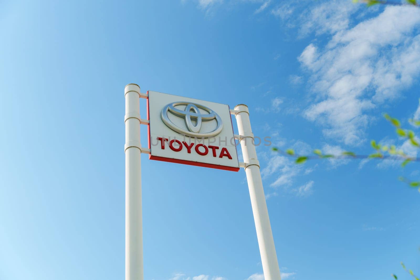 Tyumen, Russia-August 10, 2024: Toyota dealership sign under a clear blue sky with visible greenery in the foreground