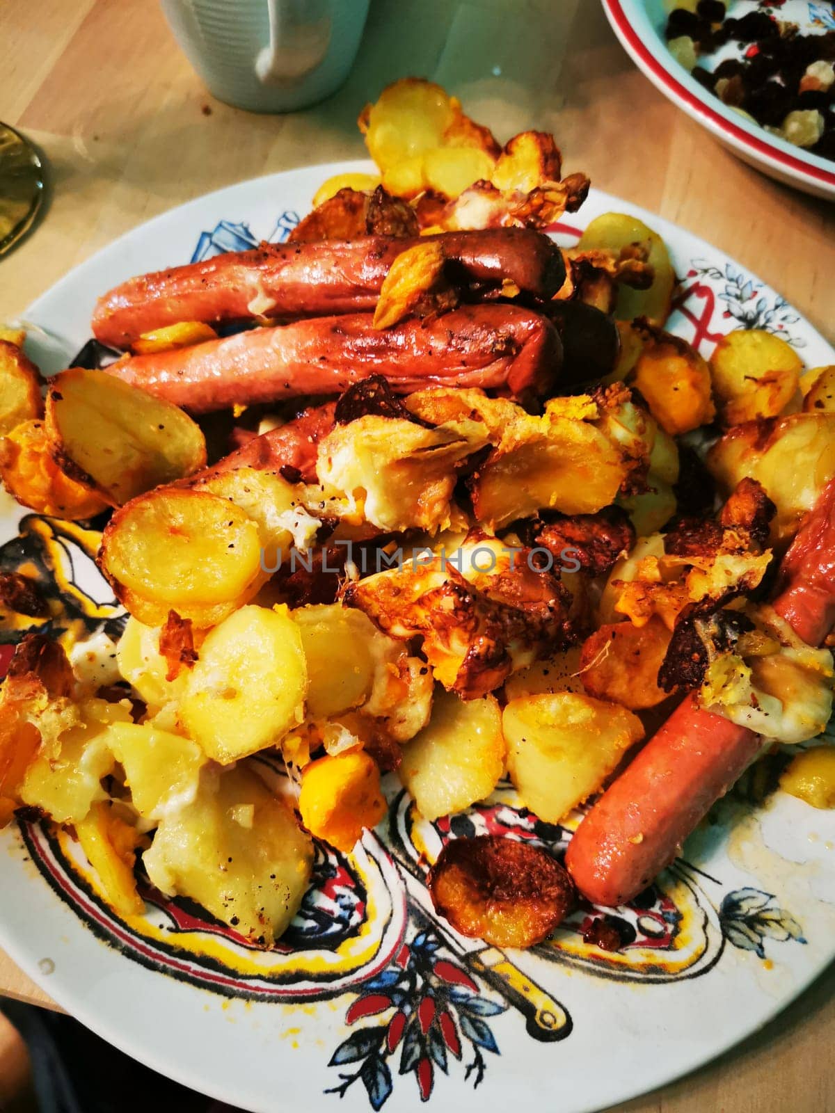 A mouthwatering dish featuring crispy golden potatoes mixed with juicy sausages, perfect for a comforting dinner in a casual setting. The vibrant plate adds charm to the meal.
