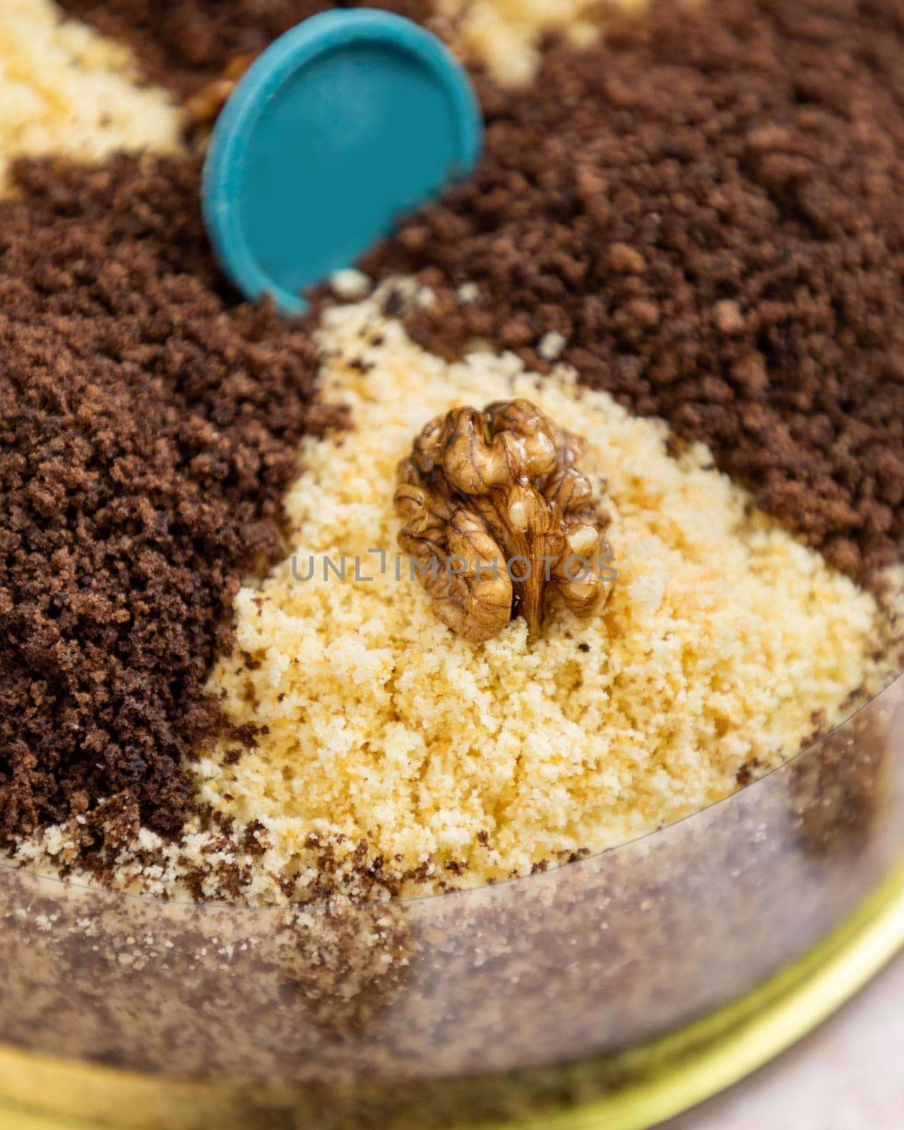 Delicious cake with chocolate and biscuit crumbs, topped with a walnut, showcasing contemporary pastry trends