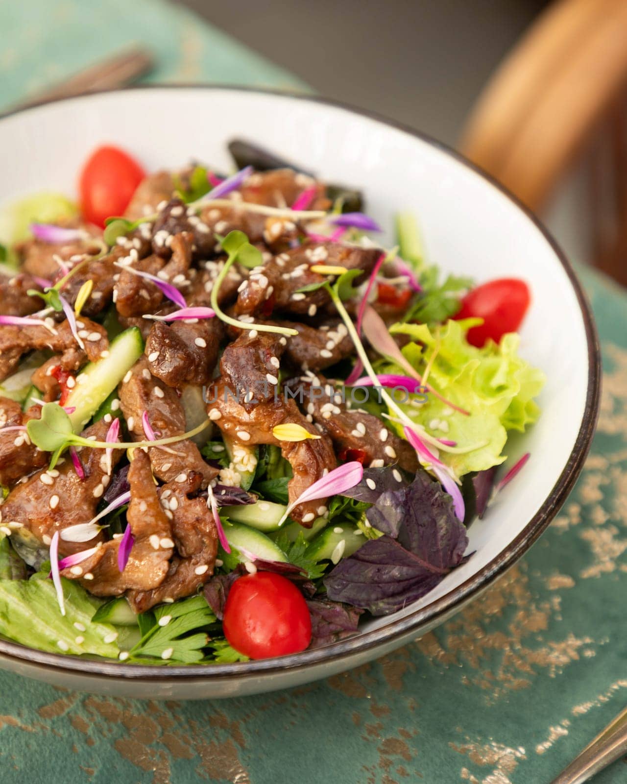 Warm salad with grilled duck breast, sesame seeds, fresh vegetables and herbs