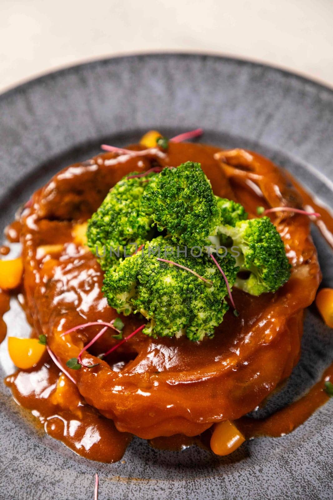 Steamed crab dish served on a plate and topped with steamed broccoli, decorated with microgreens, ready to be served