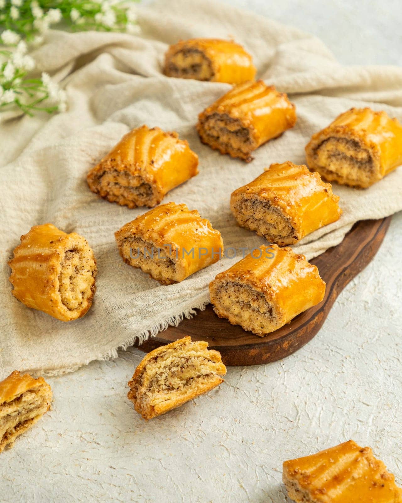 Delicious homemade poppy seed rolls with a crispy crust are lying on a white linen napkin