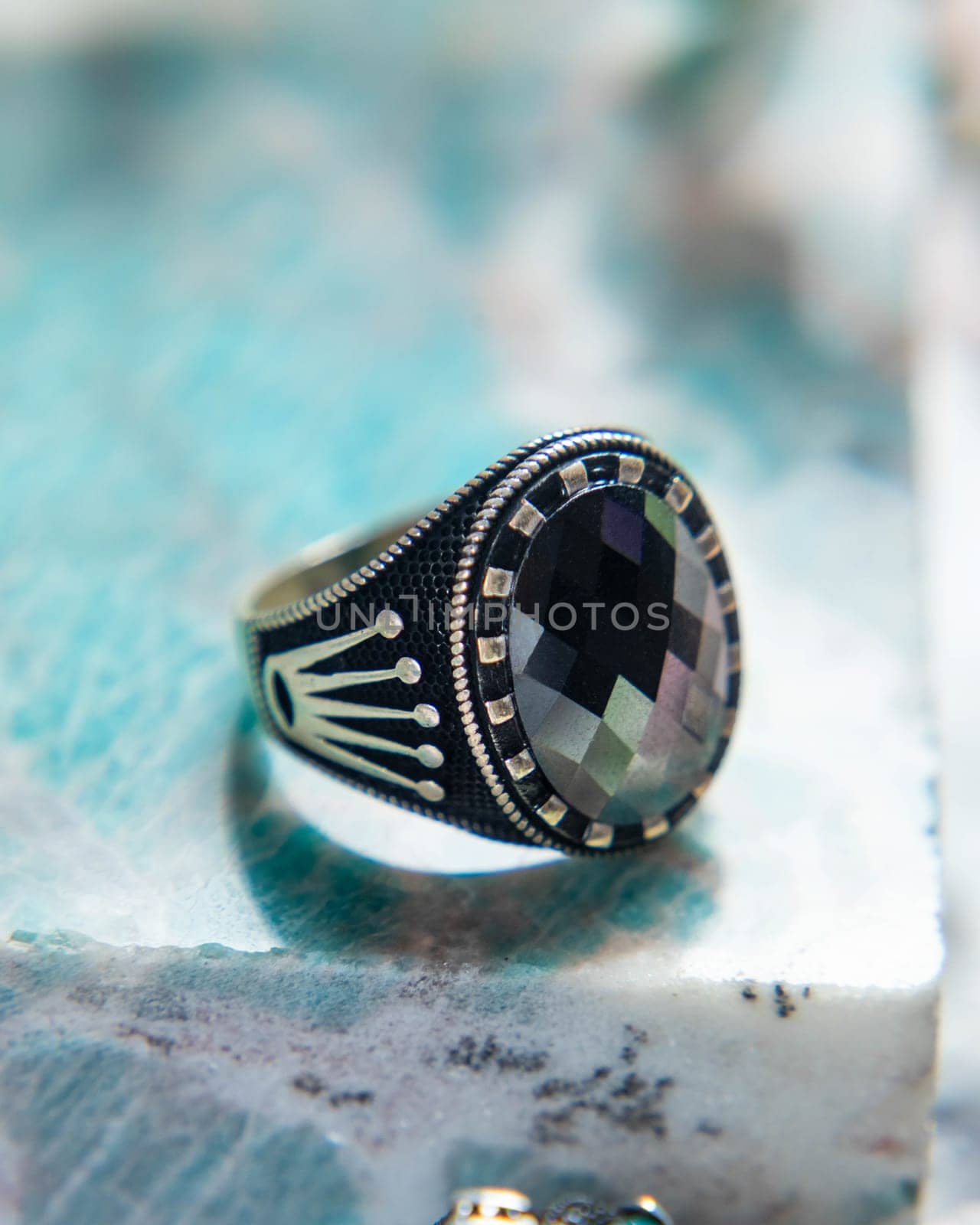 Silver ring for men with an ornate design and a large black gem in the center