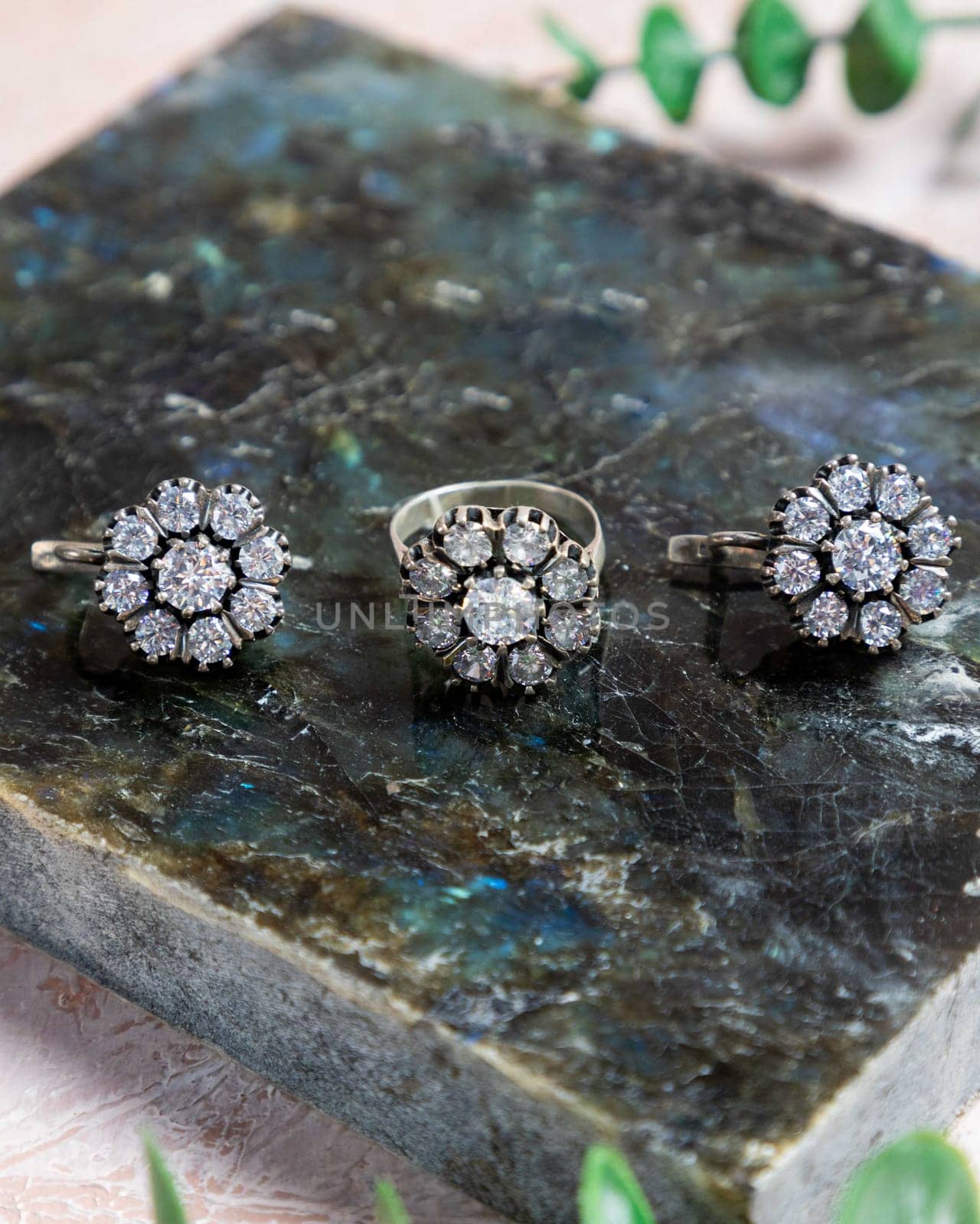 Three silver rings with zirconia are laying on a granite stone