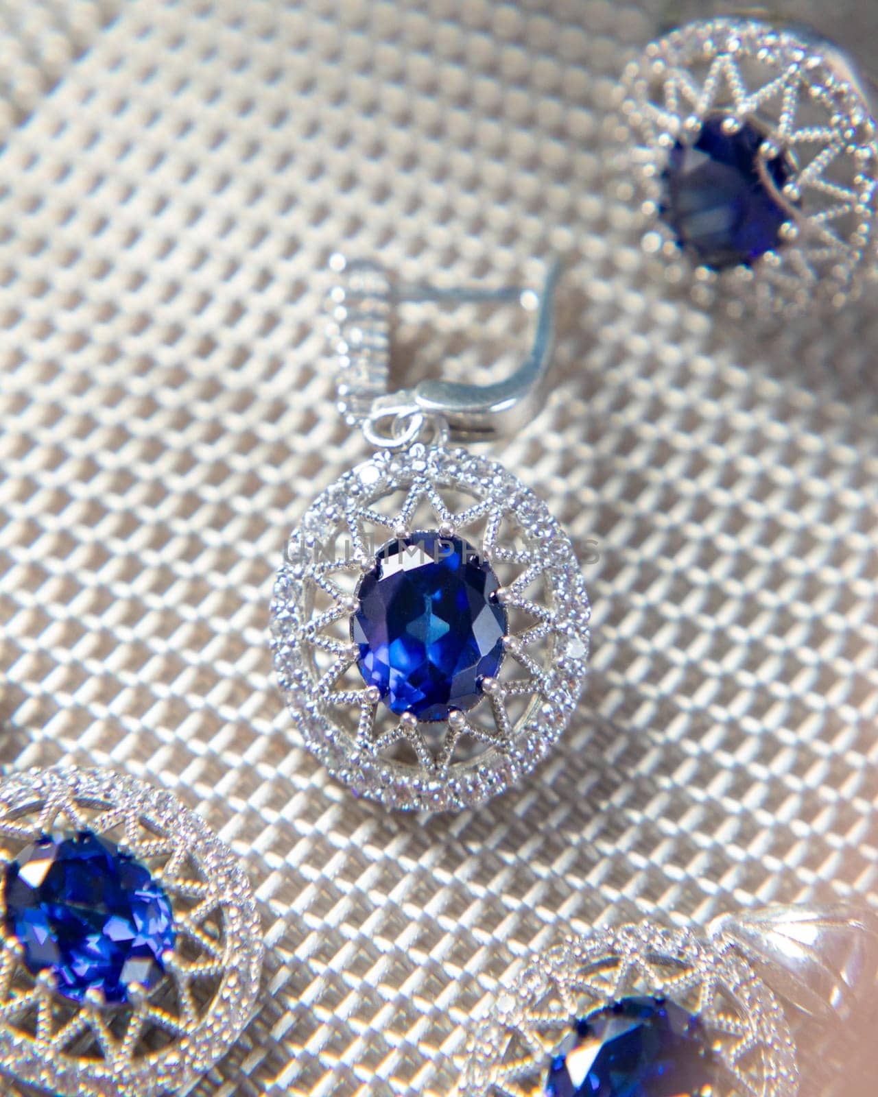 Beautiful jewelry set with large blue gemstones sparkling on white background