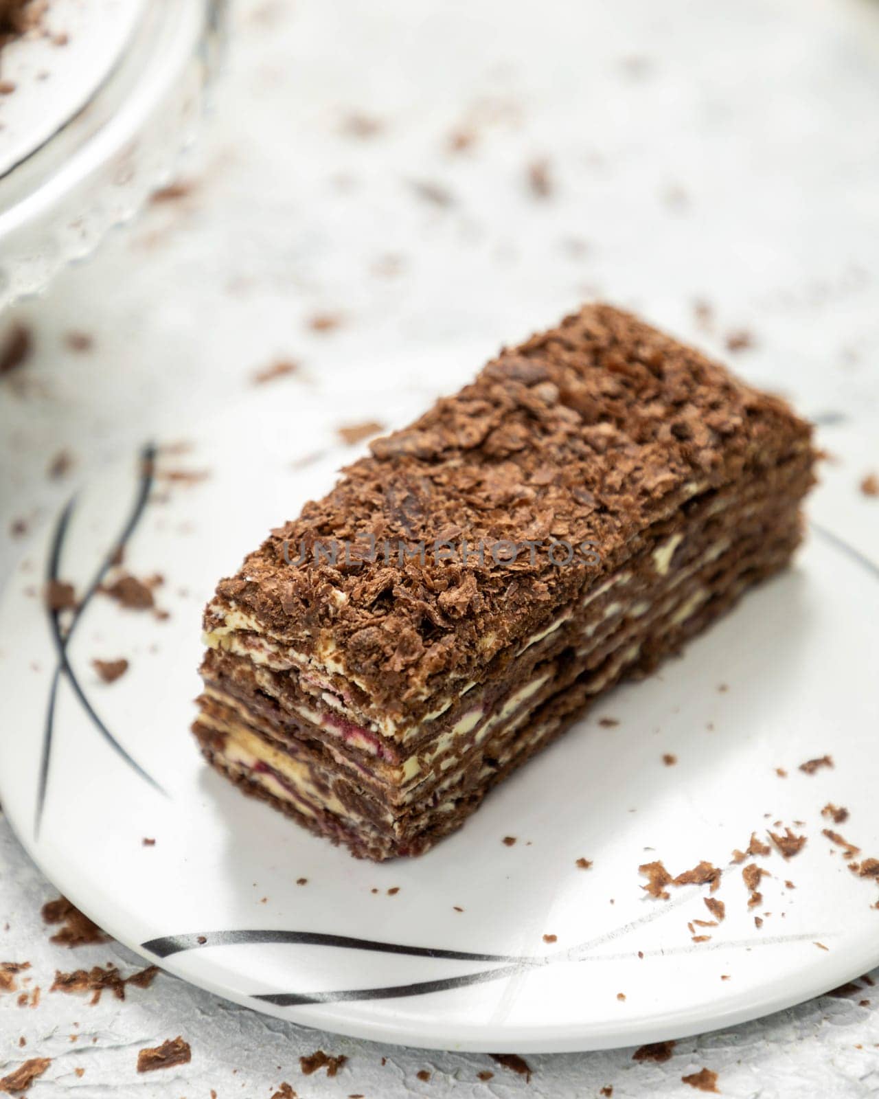 Delicious chocolate cake layered with chocolate shavings on white plate