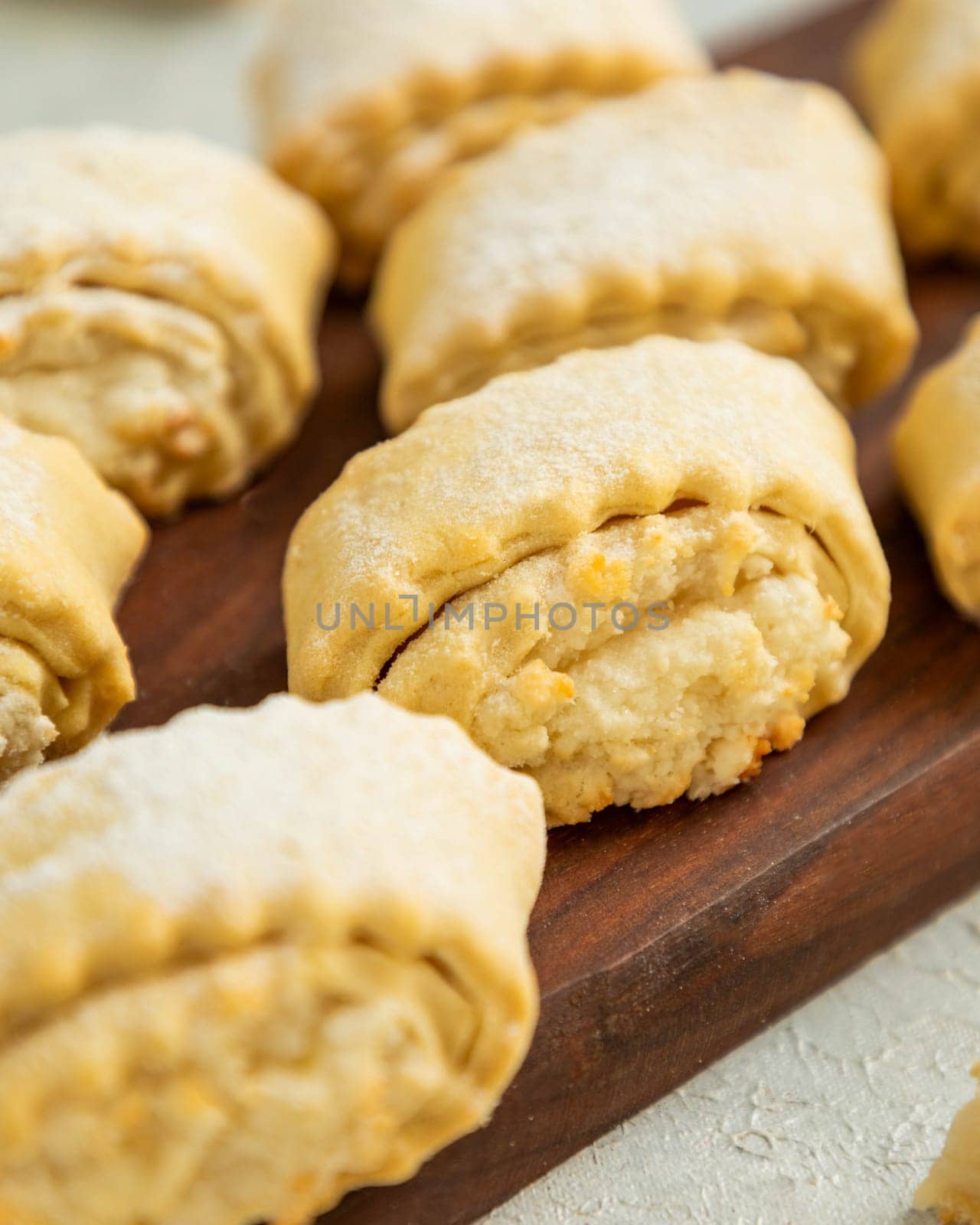 Cottage cheese cookies with powdered sugar are lying on wooden board
