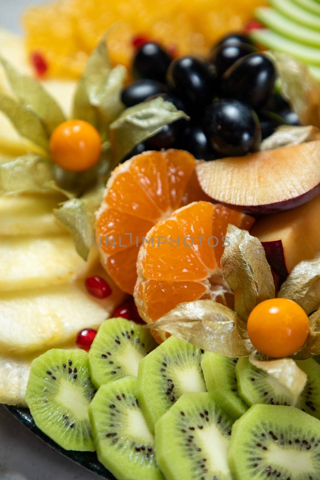 Sliced fresh fruits are arranged on a platter creating a delicious and healthy dessert