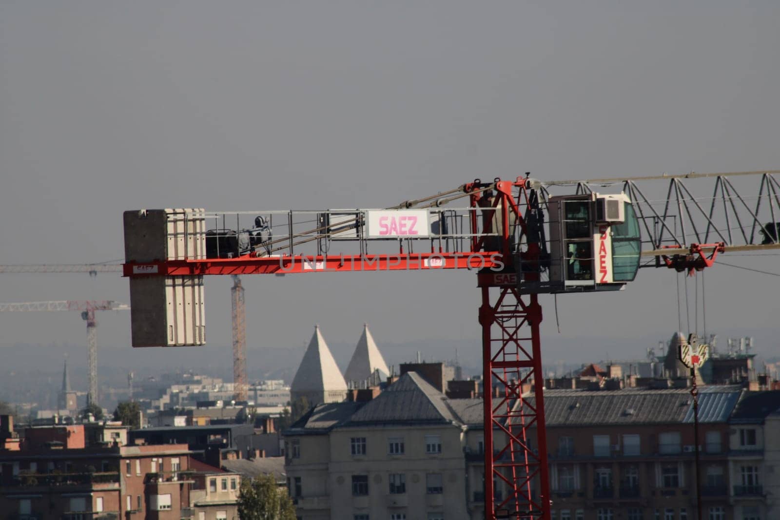 The construction crane stands prominently against the skyline, busy with construction work, showcasing the growth and development of the surrounding urban landscape.