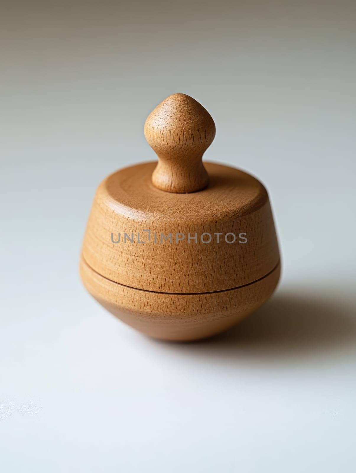 Wooden dreidel spinning on white surface for hanukkah celebration and design.