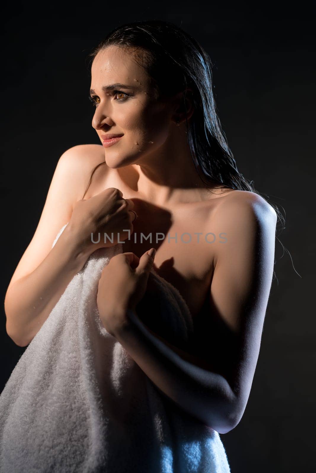 Gorgeous pregnant brunette wearing only a shirt portrait in a shower in the dark