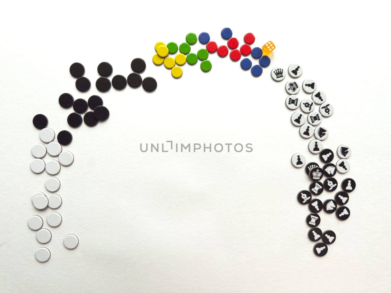 Colorful game pieces arranged in rainbow formation on white background.