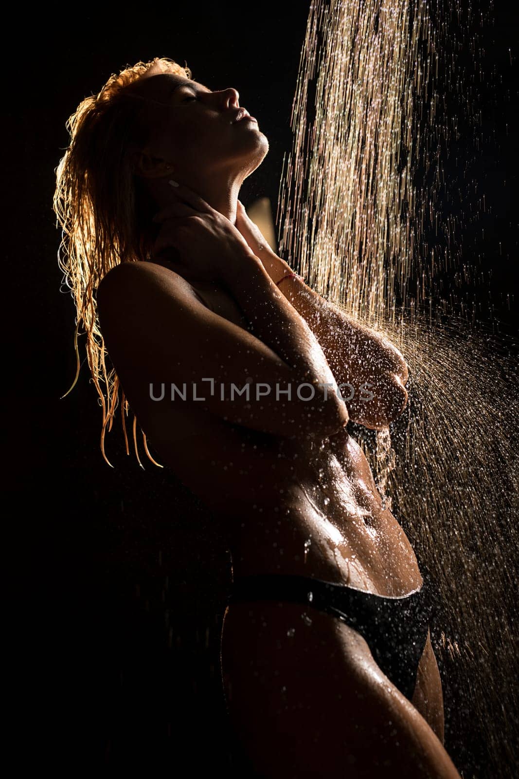 Athletic blonde topless having shower in the dark room cropped view
