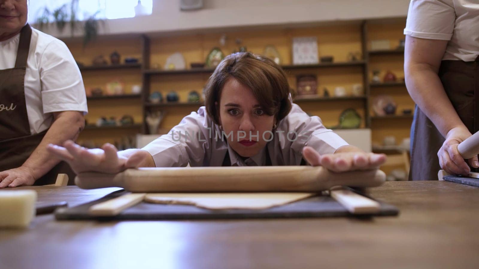 A determined and passionate baker diligently practices rolling dough in a lively and engaging cooking class environment. Stock Clip