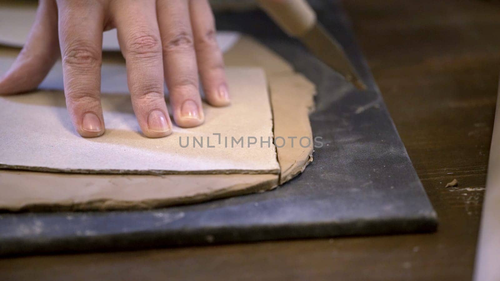 A skilled craftsman shapes soft clay on a smooth surface, showcasing intricate pottery techniques and artistry. Stock Clip