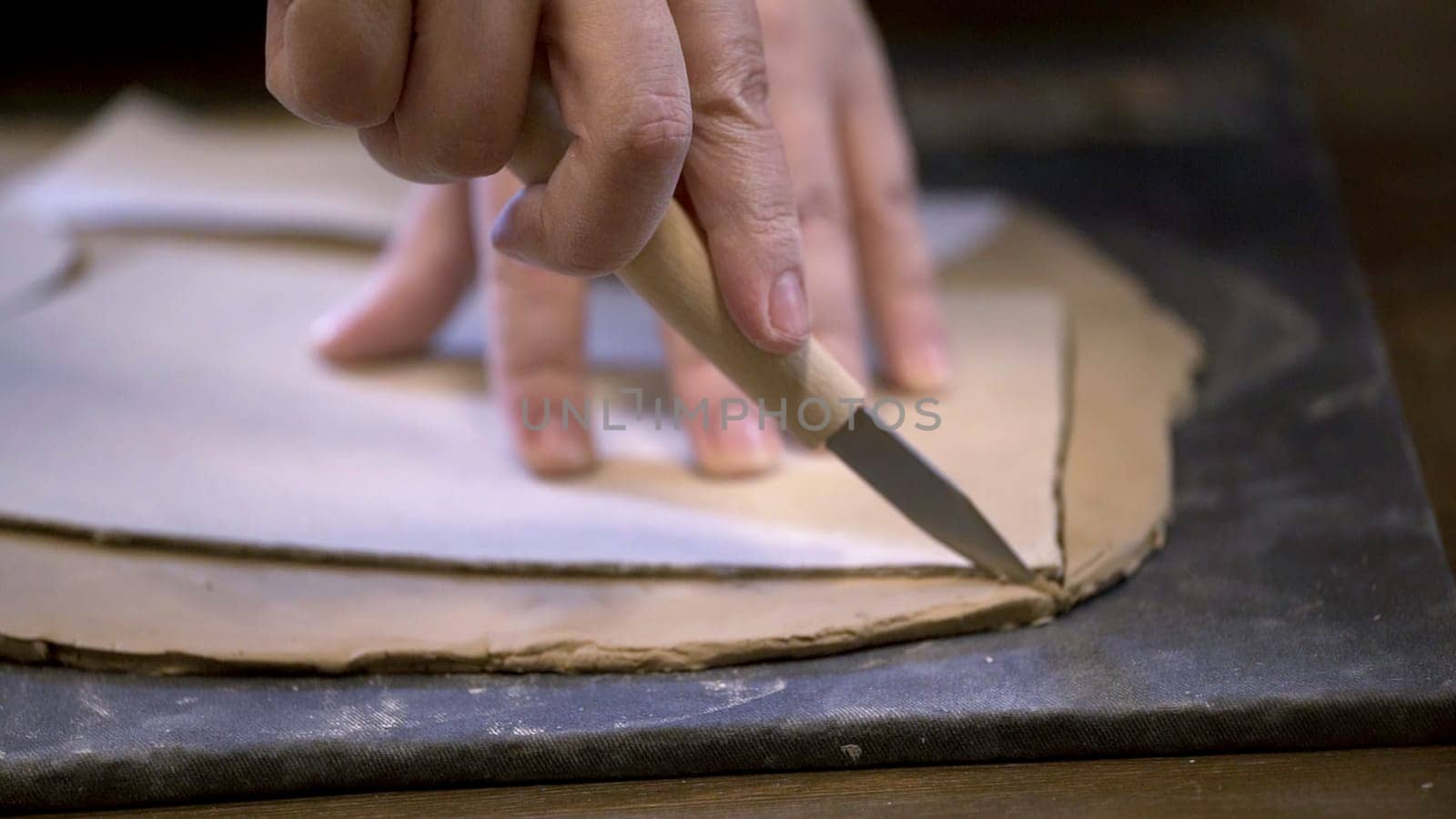 A skilled craftsman shapes soft clay on a smooth surface, showcasing intricate pottery techniques and artistry. Stock Clip