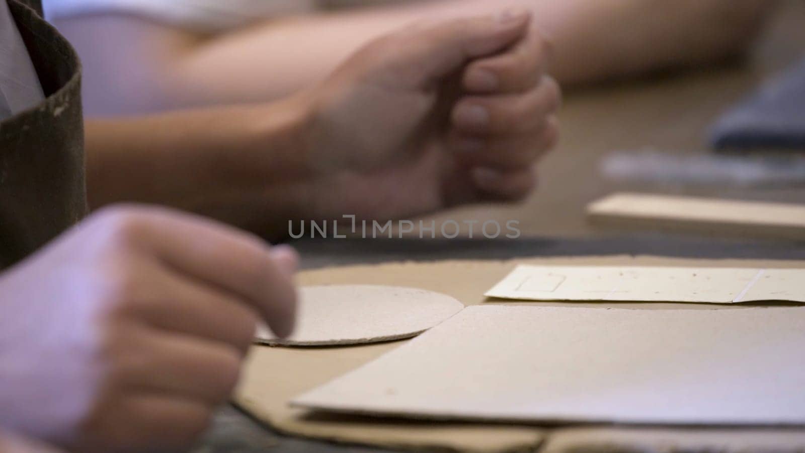 Hands skillfully shaping clay while engaged in pottery making within a creative artisan studio workshop environment. Stock Clip