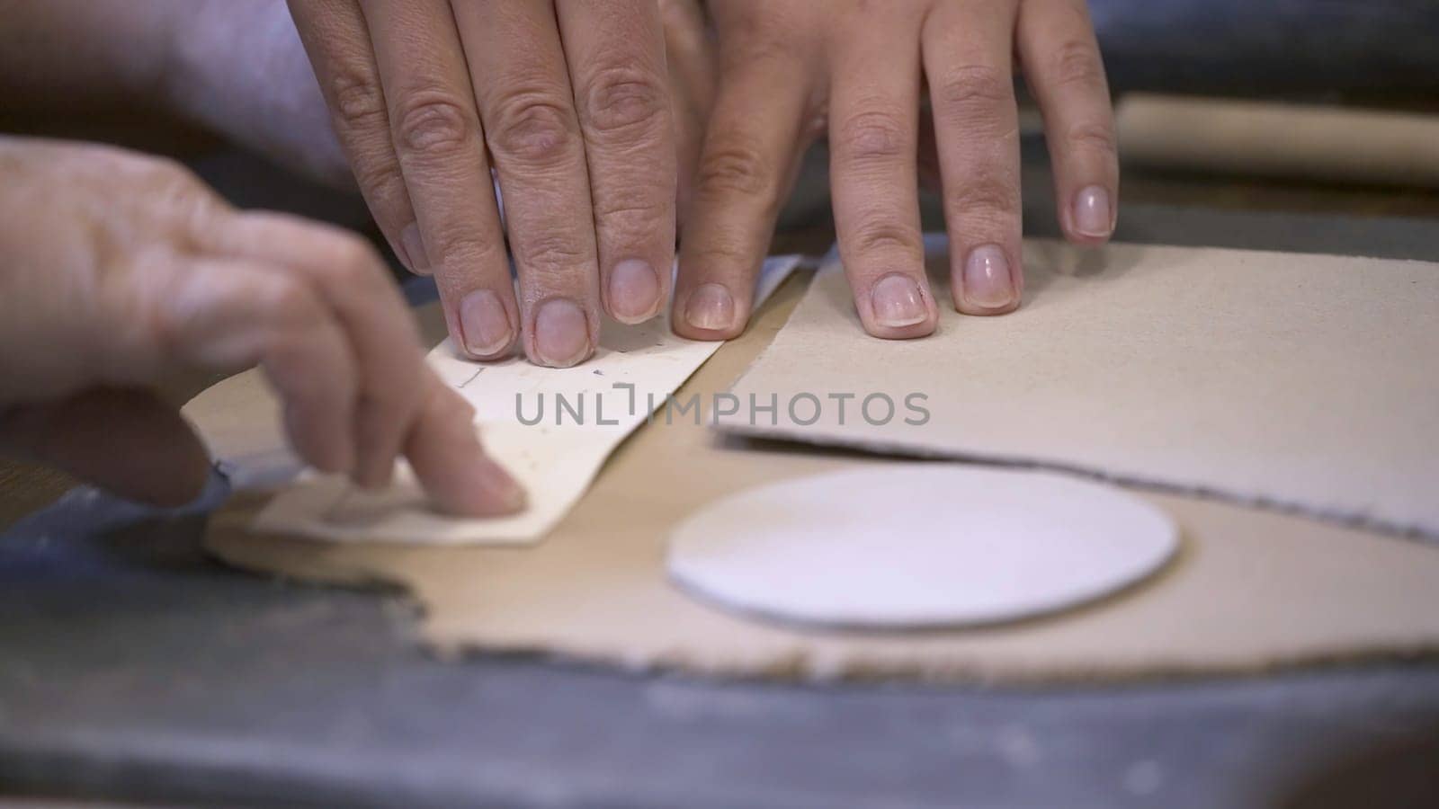Engaging in collaborative pottery making where hands skillfully shape clay using various essential tools. Stock Clip
