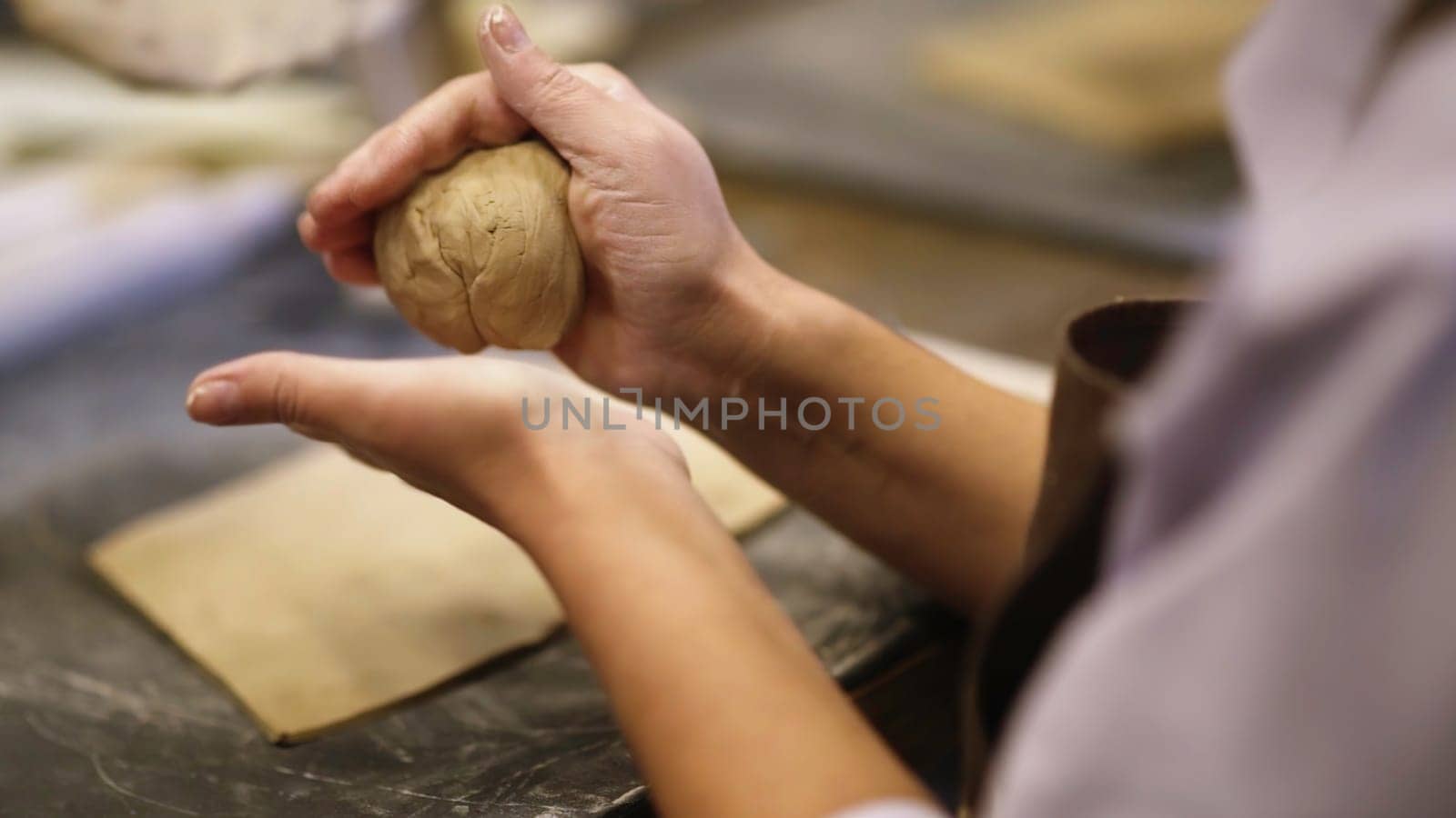 Talented artists shaping wet clay in a busy pottery workshop, showcasing their remarkable skill and creativity. Stock Clip