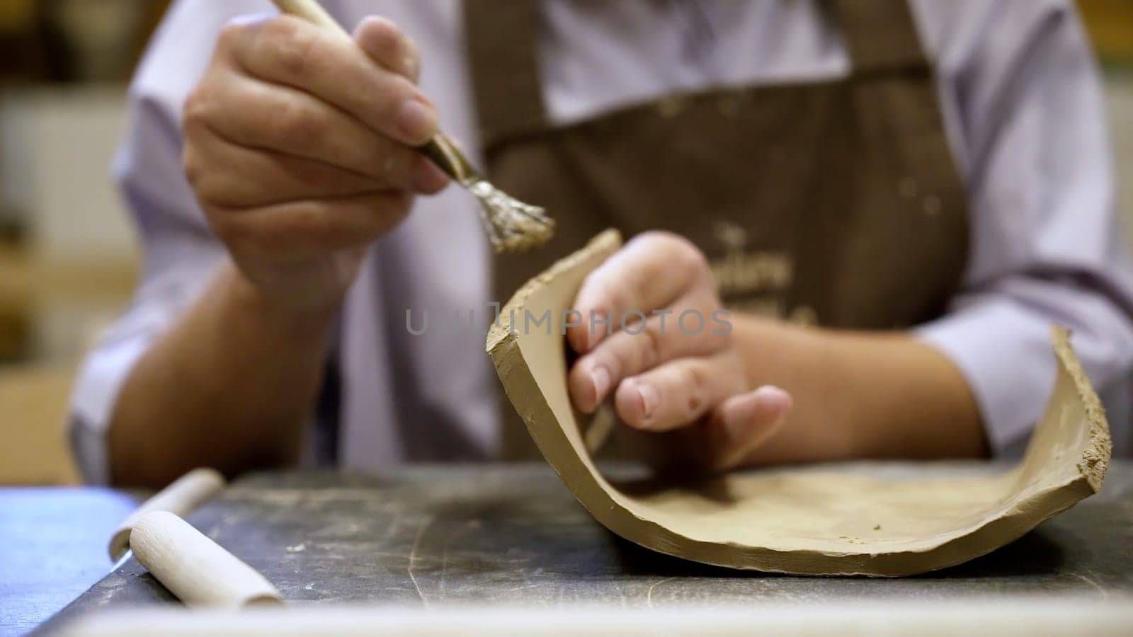 A skilled and dedicated artisan meticulously shapes clay pottery, showcasing great attention to detail and creativity. Stock Clip