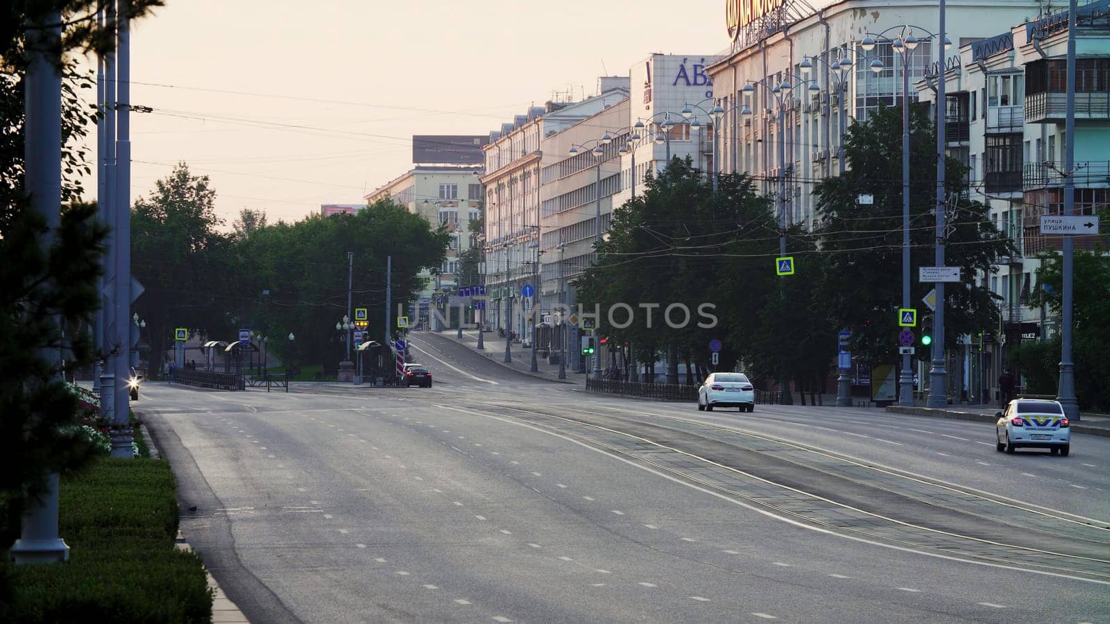A beautifully serene early morning view of the empty streets lined with green trees and fascinating buildings. Stock Clip
