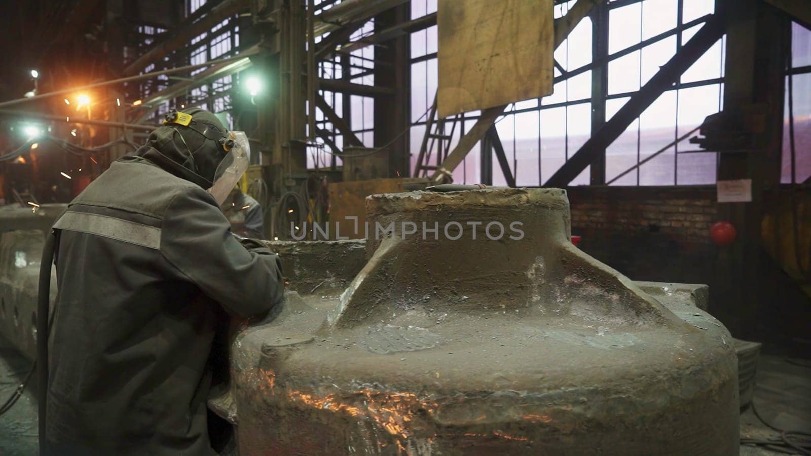 A bustling industrial workshop filled with workers actively engaged in numerous heavy machinery tasks and operations. Stock Clip