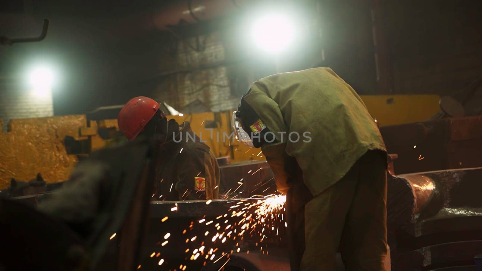 Skilled metalworkers engage in intricate work, showcasing sparks in a vibrant setting where creativity thrives. Stock Clip