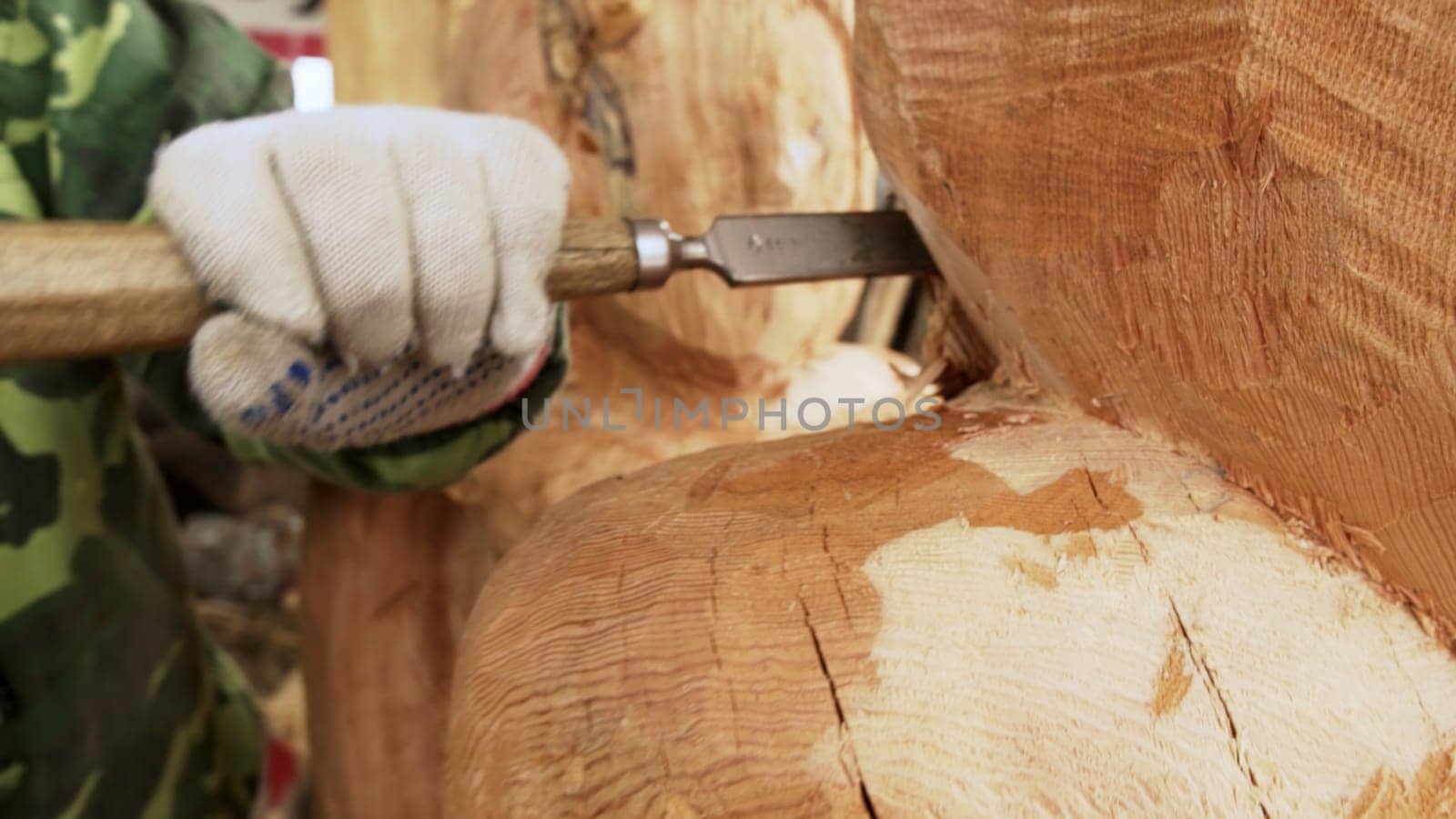 A skilled craftsman meticulously chisels and carves wood, effectively showcasing the beauty of craftsmanship and art. Stock Clip
