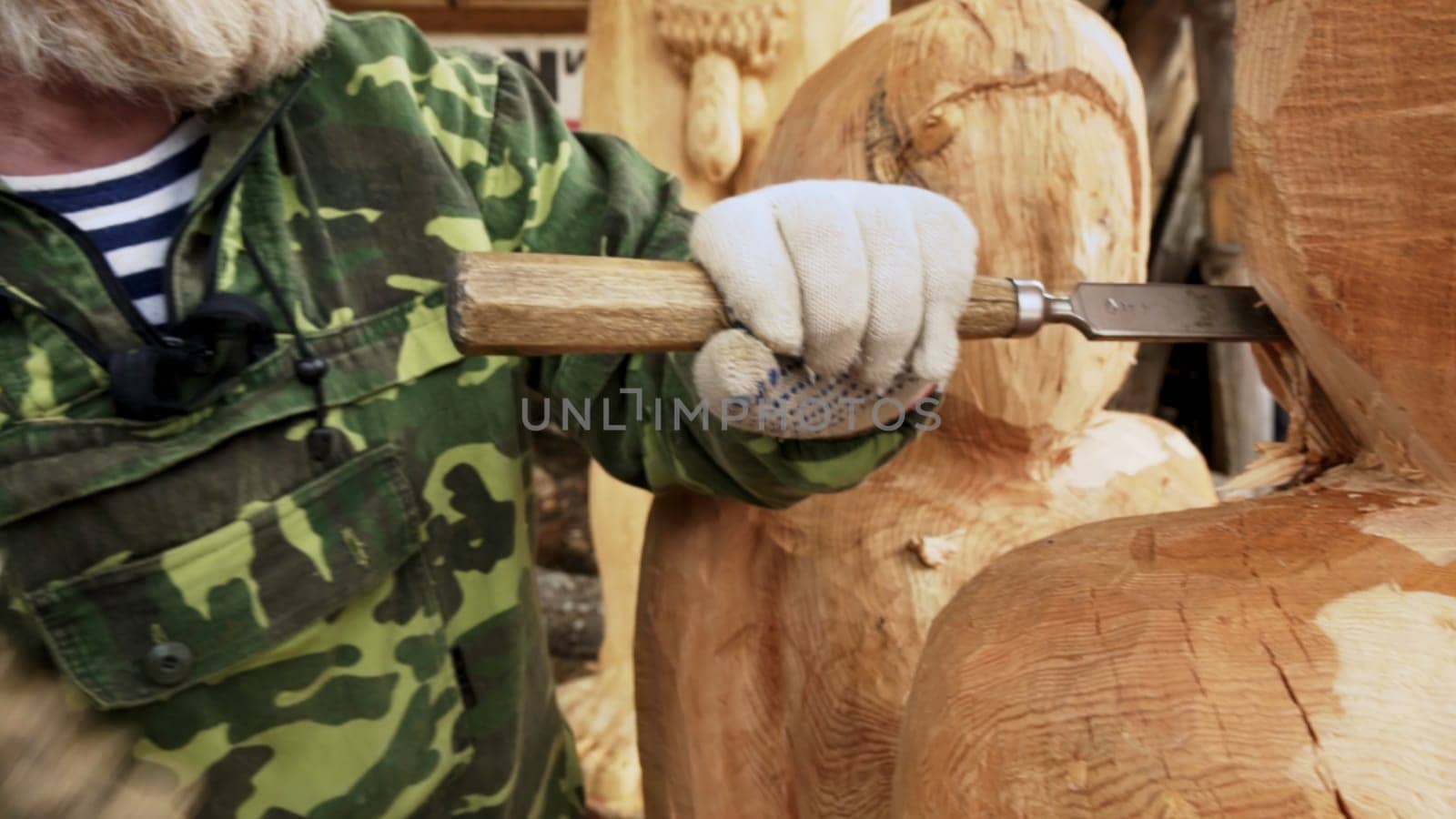 A skilled craftsman meticulously chisels and carves wood, effectively showcasing the beauty of craftsmanship and art. Stock Clip