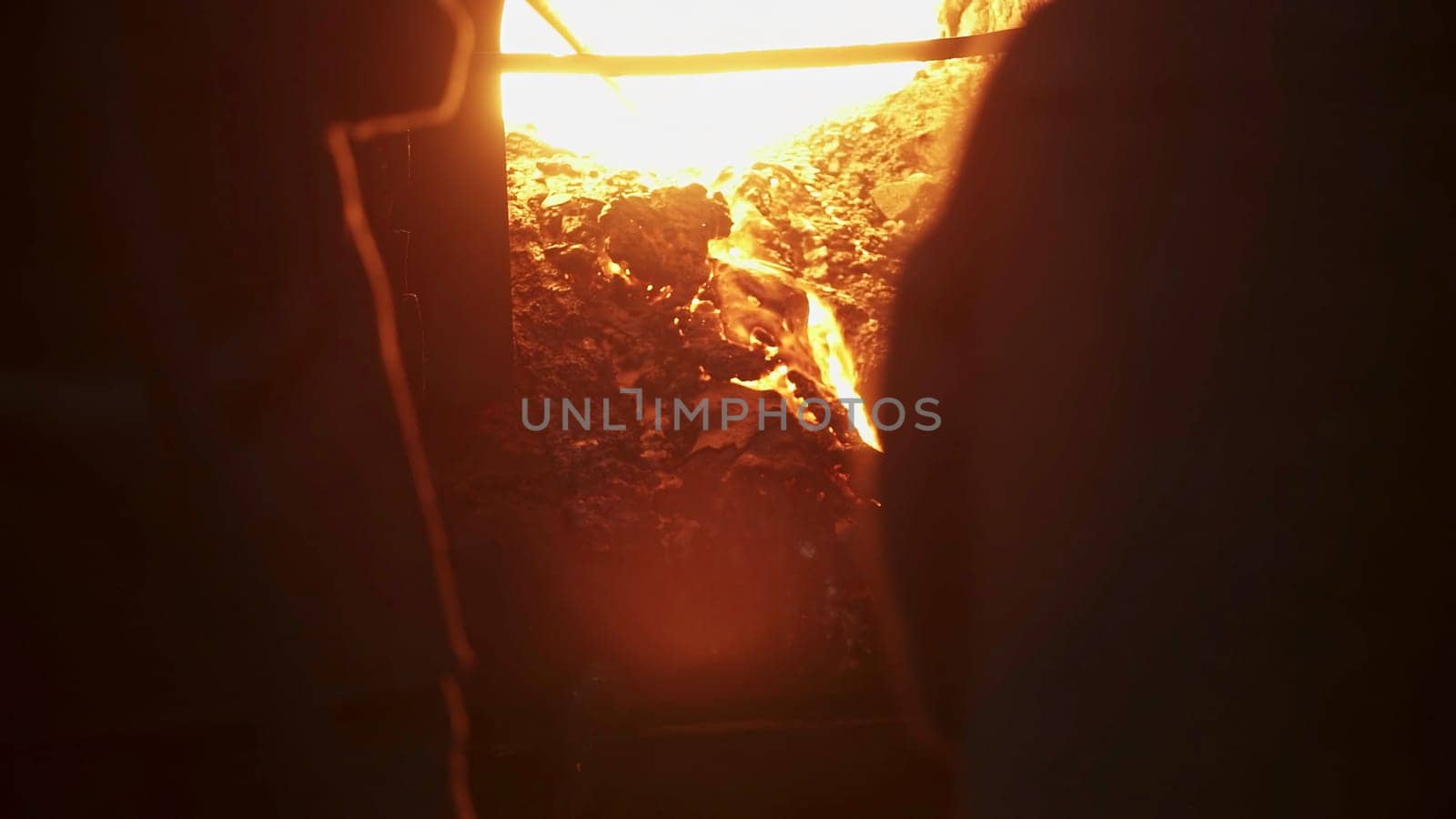 An artisan skillfully working with molten materials in a dimly lit workshop environment filled with creativity. Stock Clip