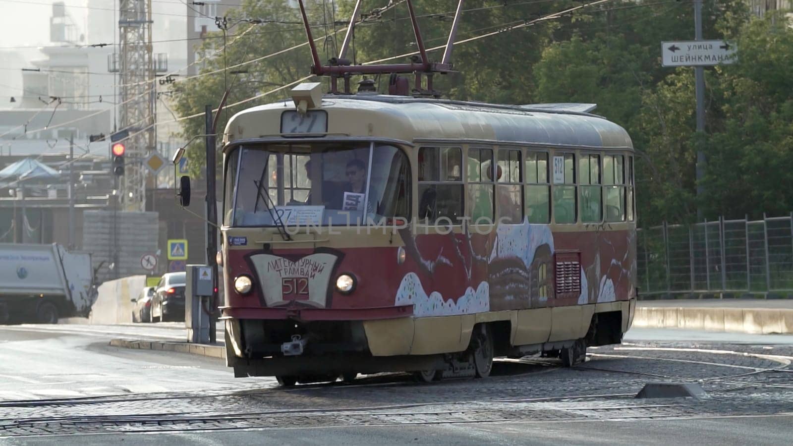 Tbilisi, Georgia - September 29, 2023: A charming, vintage tram gracefully navigating through a bustling urban environment during the early dawn hours. Stock Clip