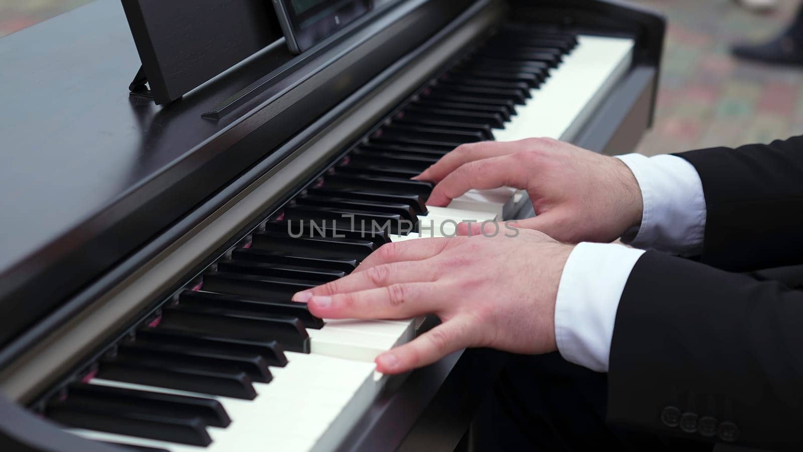 A close-up of hands playing a digital piano, capturing the artistry and elegance of music performance. Clip