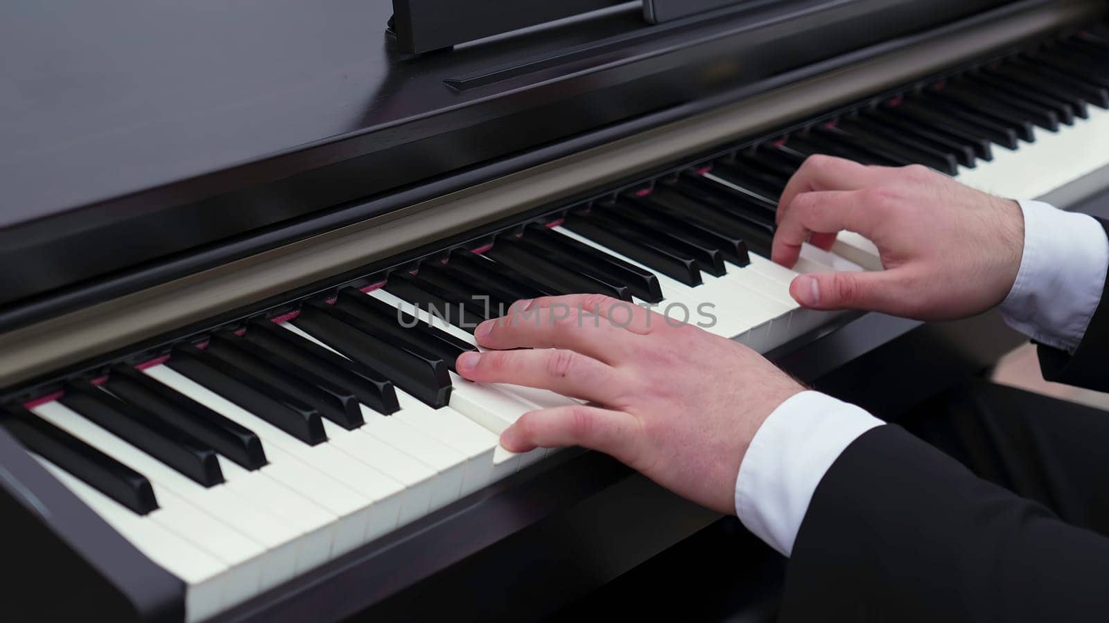 A skilled pianist is performing beautifully on a digital keyboard, showcasing their talent and passion for music. Clip