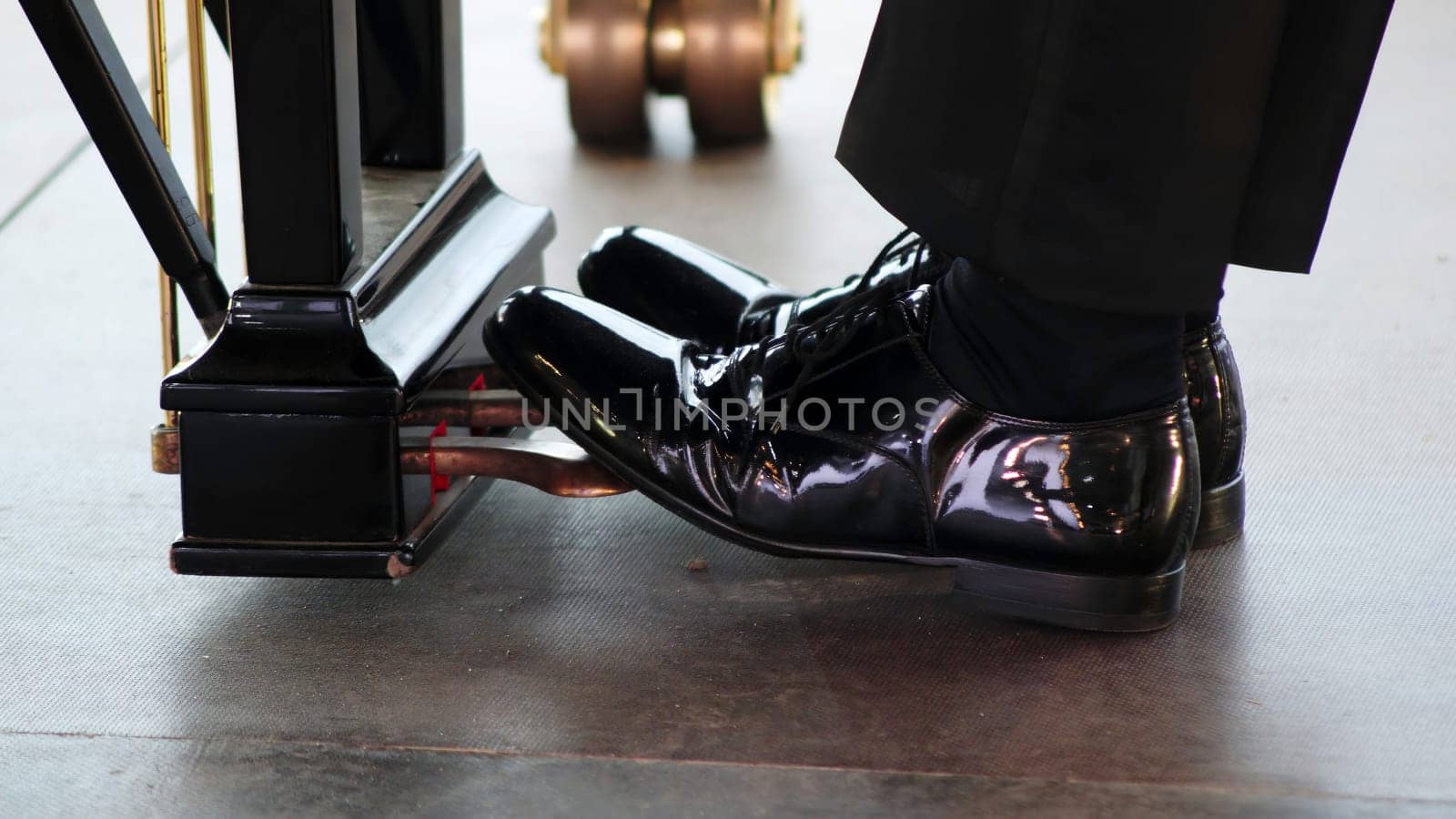 An artistic scene capturing a pianists polished shoes on a pedal, showcasing an atmosphere of grace. Clip