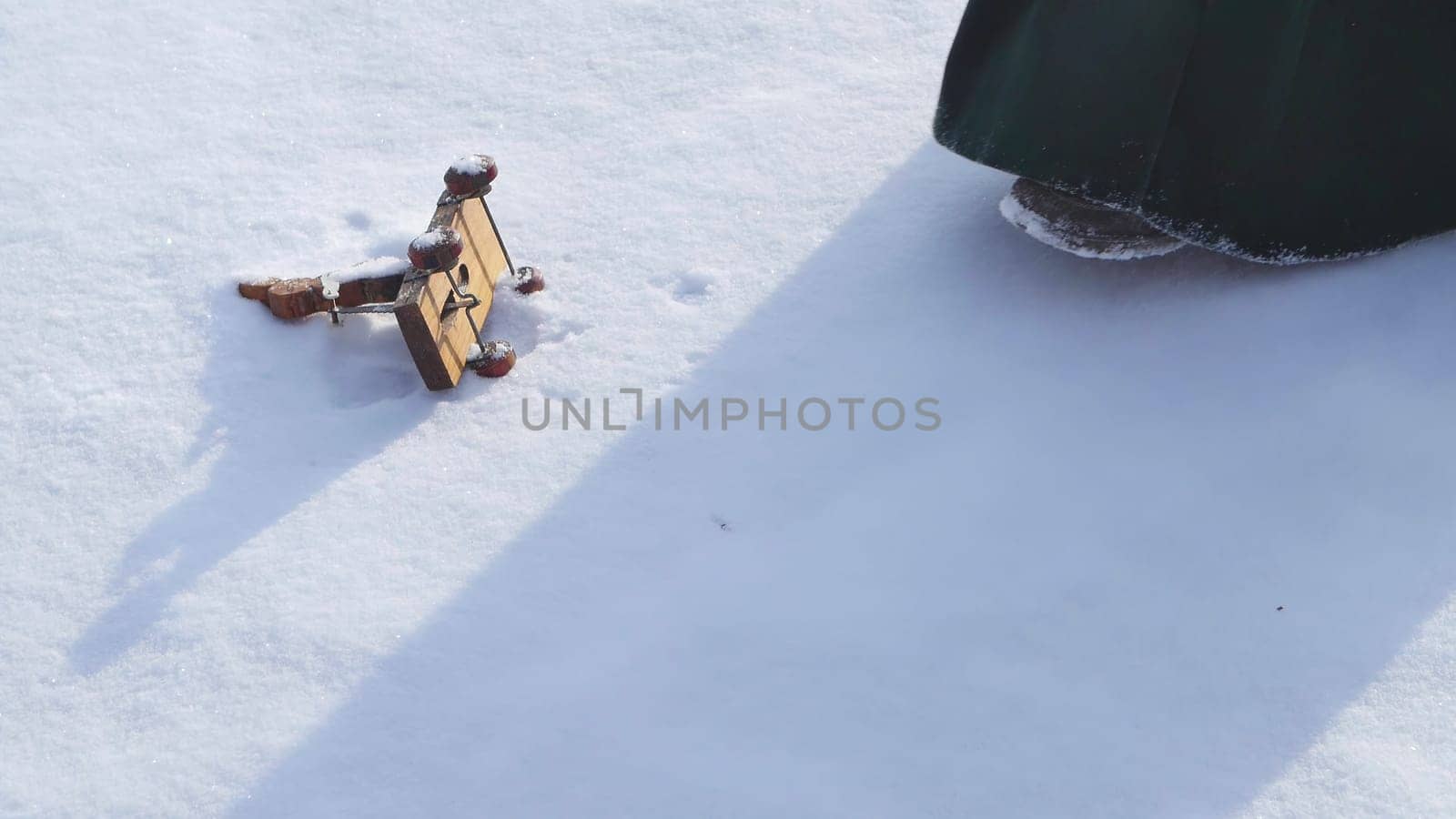 In a serene winter landscape, a piece of wood rests in the snow as a person contemplates the beauty, reflecting on natures tranquility