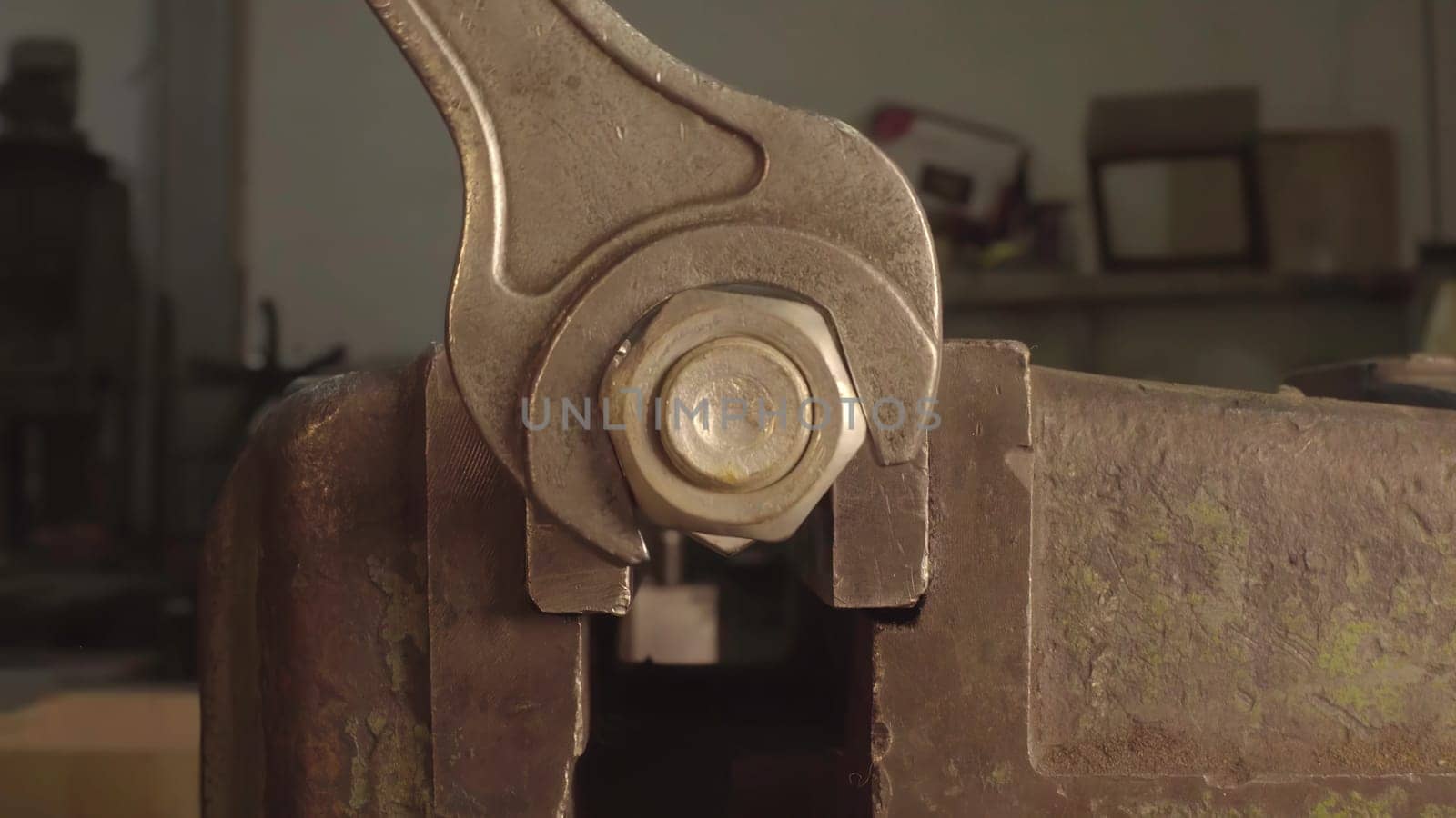 This video shows how to use a wrench for metal tasks, starting with removing a nut from a bolt, then tightening another in a vise, and ending with a closeup of a metal object