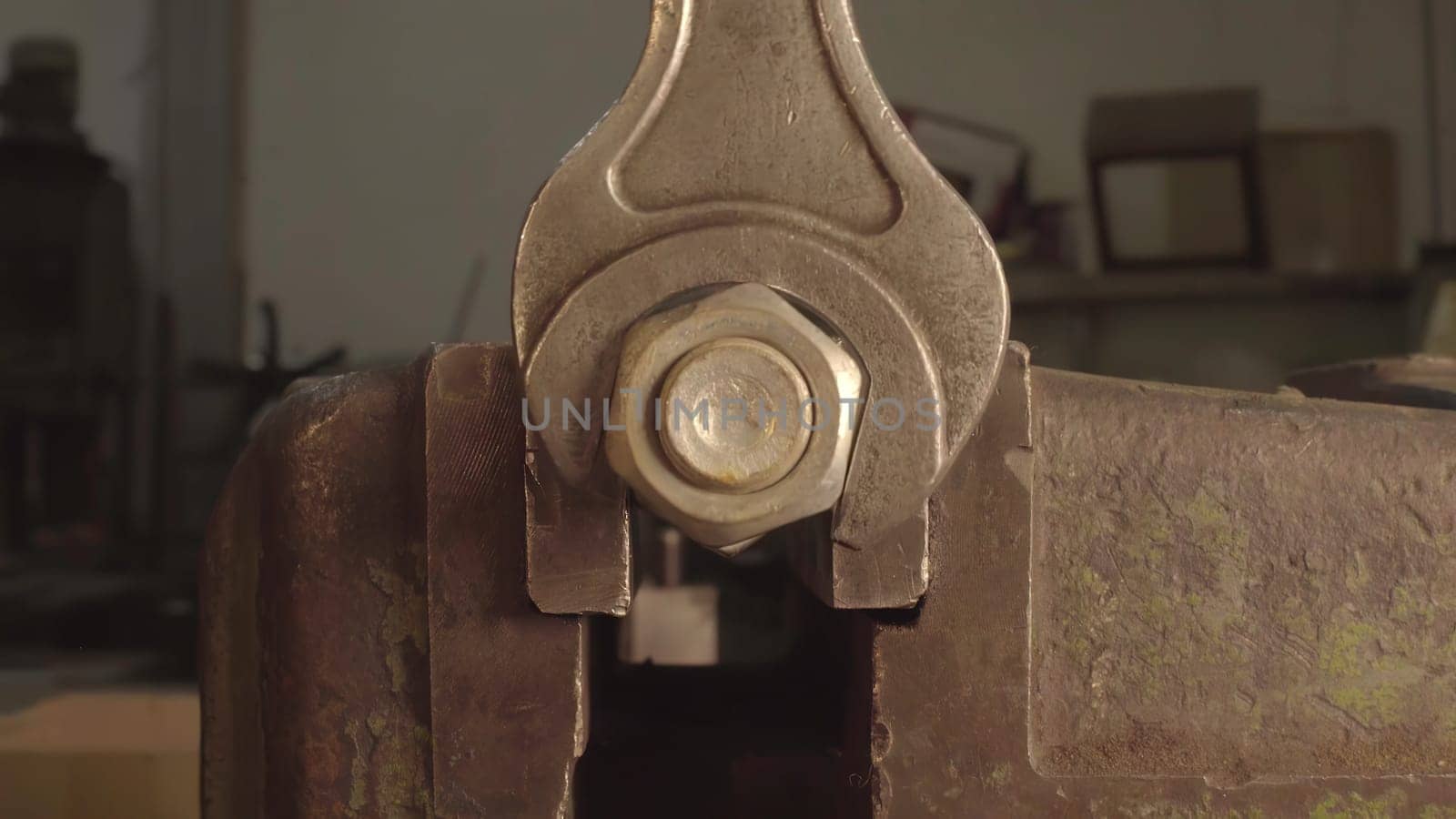This video shows how to use a wrench for metal tasks, starting with removing a nut from a bolt, then tightening another in a vise, and ending with a closeup of a metal object