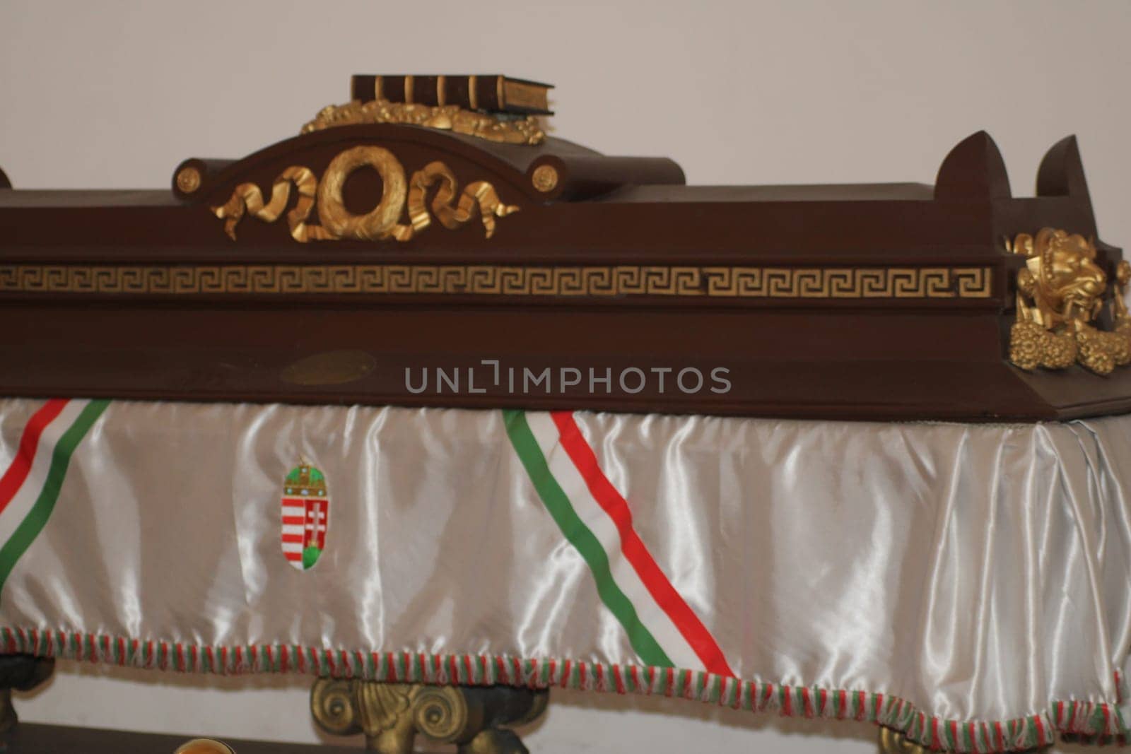 A beautifully crafted wooden coffin featuring intricate gold carvings is on display at a museum in Hungary, representing its rich cultural history and artistry.
